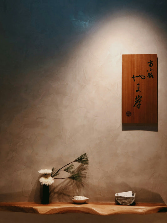 a wooden shelf with a vase and flowers on it