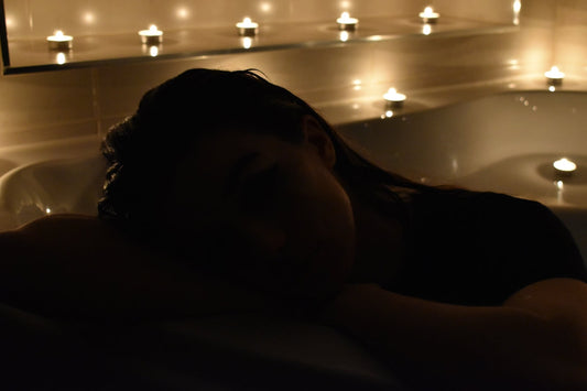 Woman relaxing in a candlelit bathtub at-home spa bath