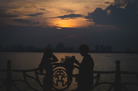 a couple of people standing next to a body of water