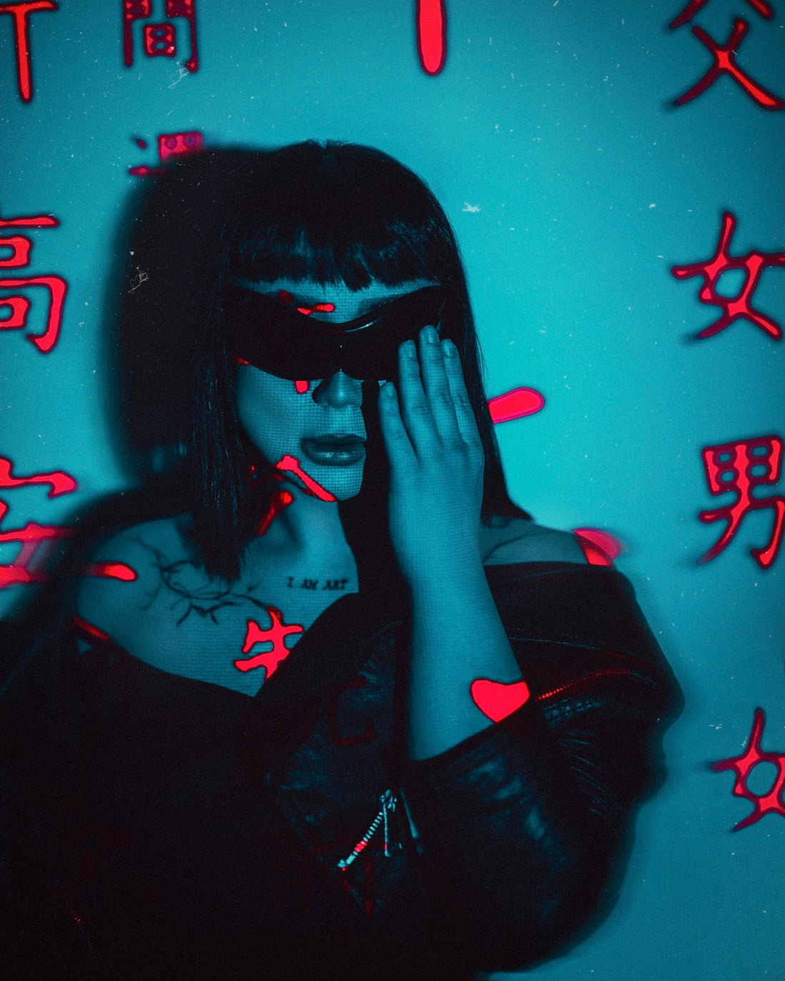a woman in a black leather jacket holding her hands to her face