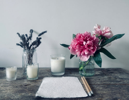 Flowers, candles, and pencils on a wooden table.
