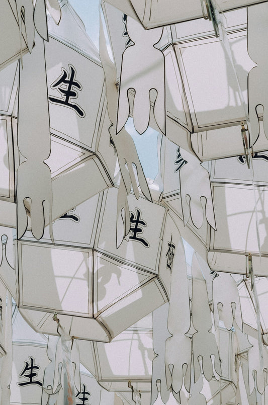 White lanterns with asian characters hang close together.