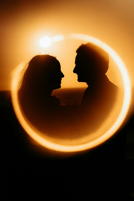 Silhouettes of a couple looking at each other at sunset